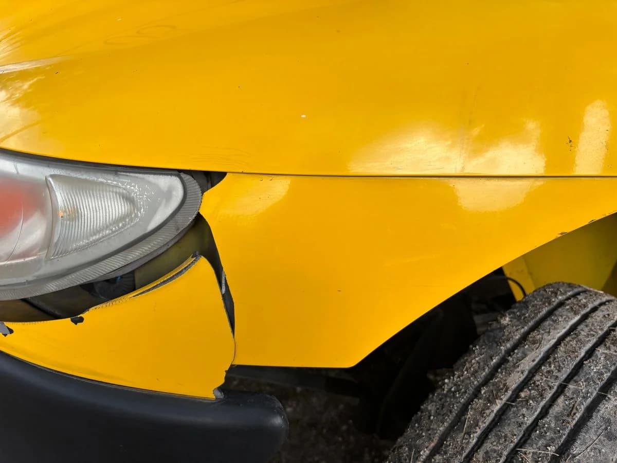 A crash-damaged car being removed after an accident